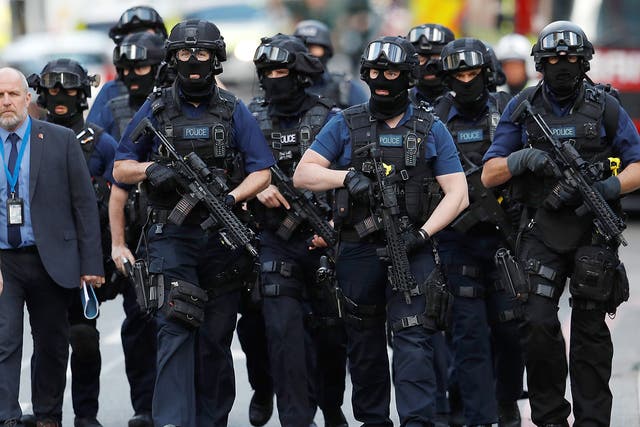 Armed police officers walk outside Borough Market after an attack left 6 people dead and dozens injured in London