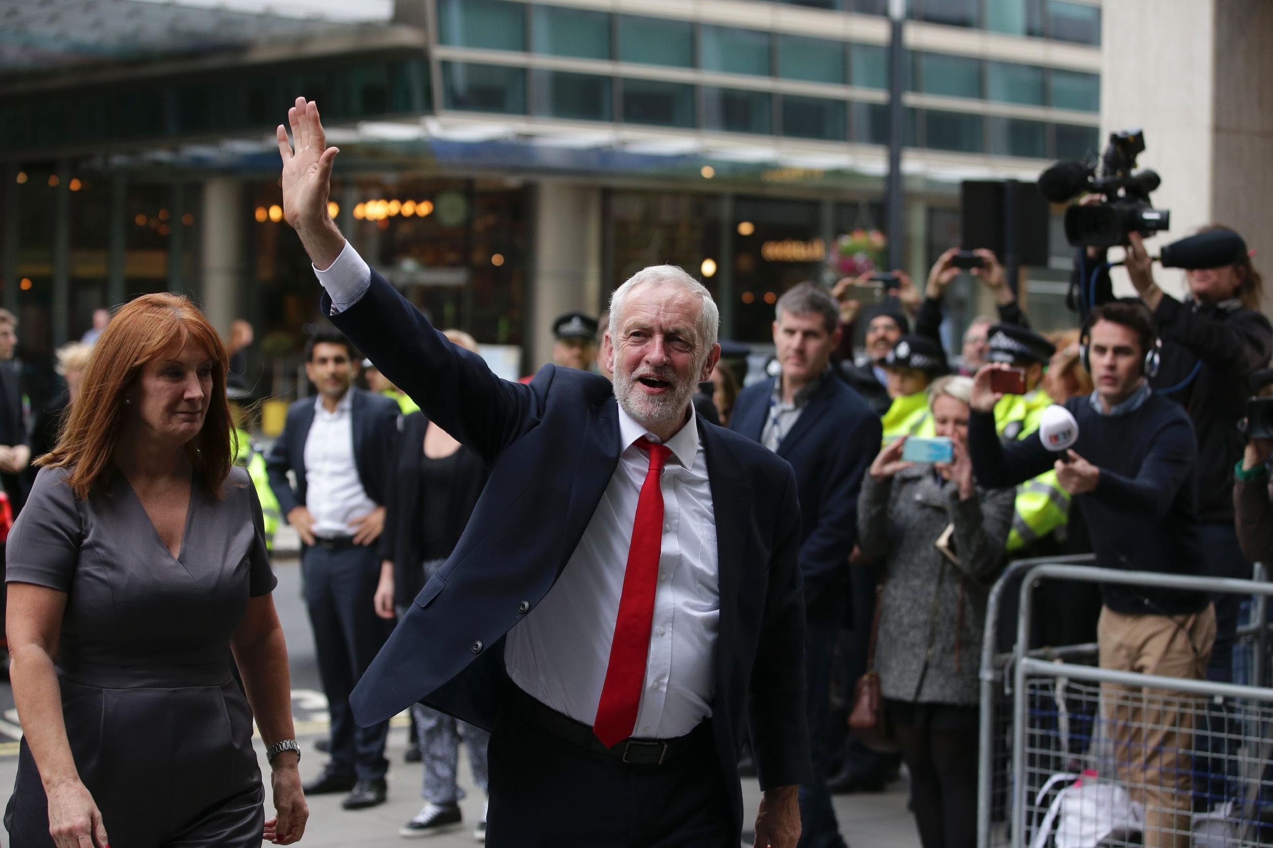 Labour Party Leader Jeremy Corbyn waves as he arrives at Labour Party headquarters in central London after the results of a recent snap election