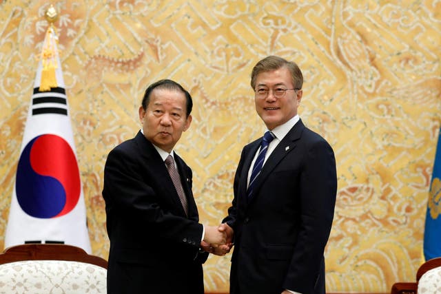 South Korean President Moon Jae-in (right) shakes hands with Toshihiro Nikai, Secretary General of the Japanese Liberal Democratic Party, during their meeting at the Presidential Blue House in Seoul