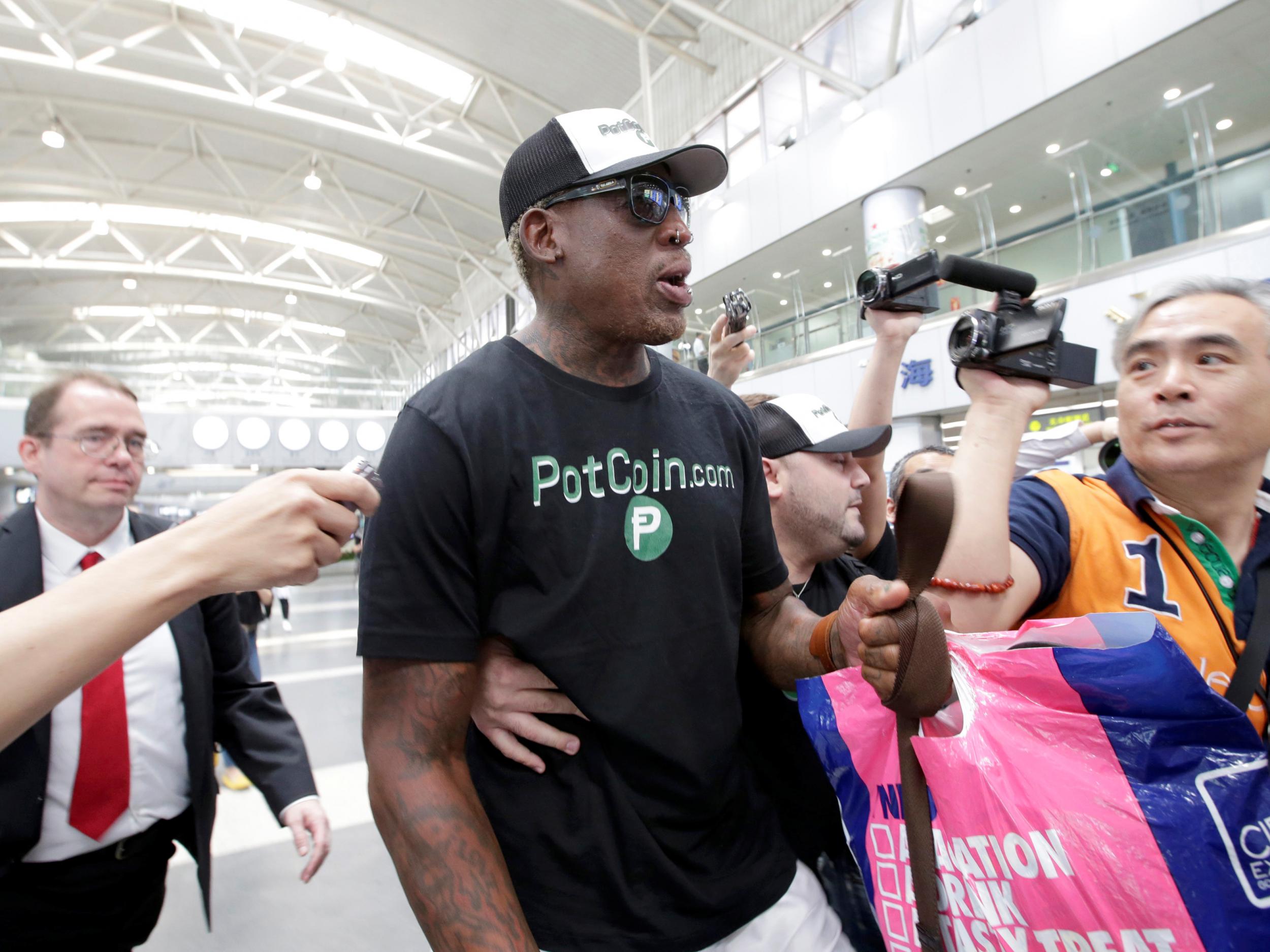 Former NBA basketball player Dennis Rodman speaks to the media as he leaves for North Korea's Pyongyang at Beijing Capital International Airport, China