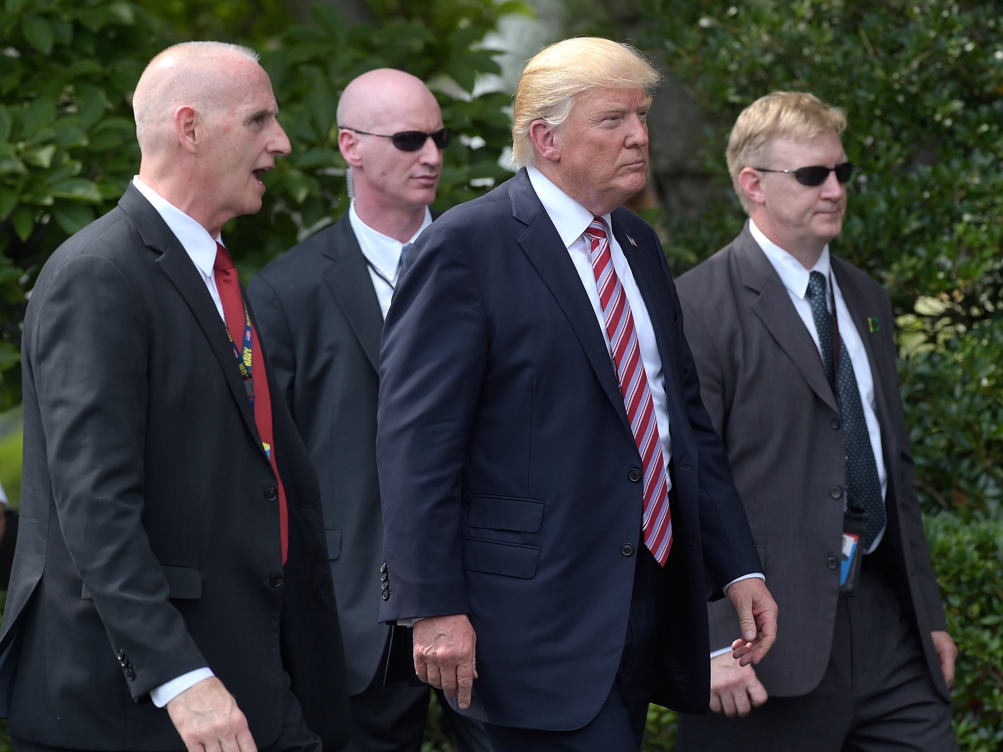 President Donald Trump, his longtime bodyguard Keith Schiller, left, and two Secret Service agents walk along the South Lawn of the White House