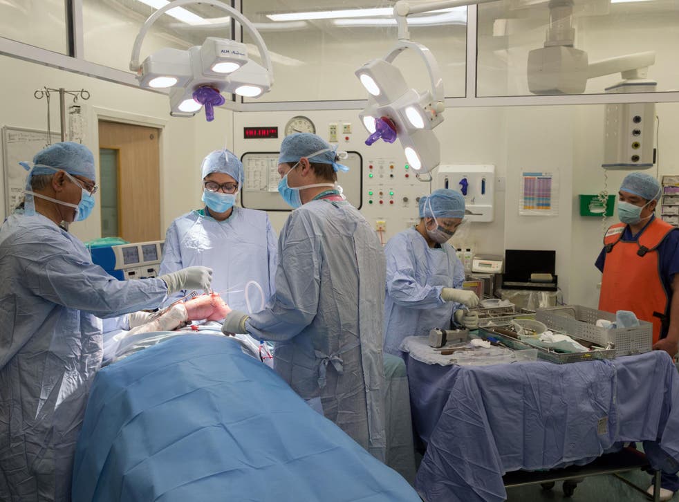 <p>NHS surgeons and hospital staff during an operation</p>