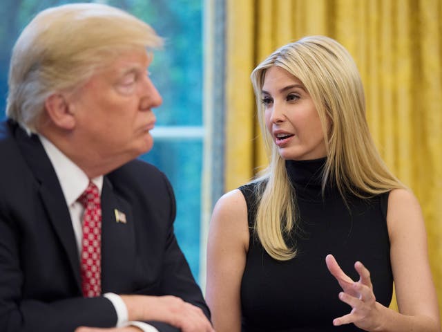 United States President Donald Trump listens while his daughter Ivanka speaks