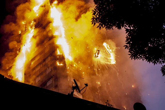 Falling burning debris at the scene of a huge fire at Grenfell tower block