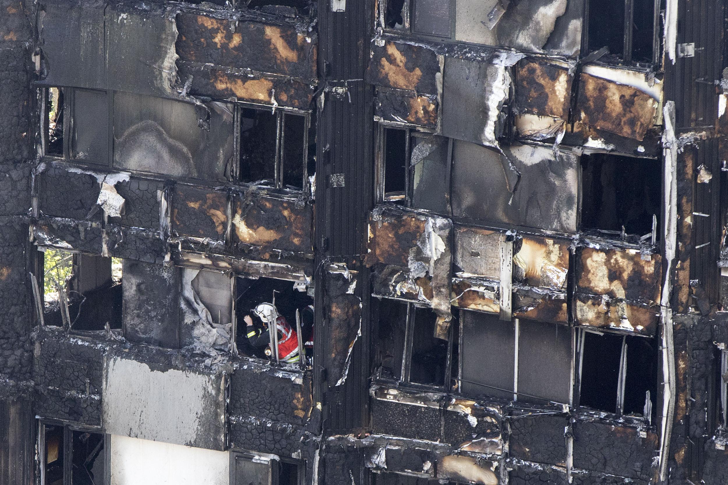 A firefighter investigates a floor after a fire engulfed the 24-storey Grenfell Tower in west London