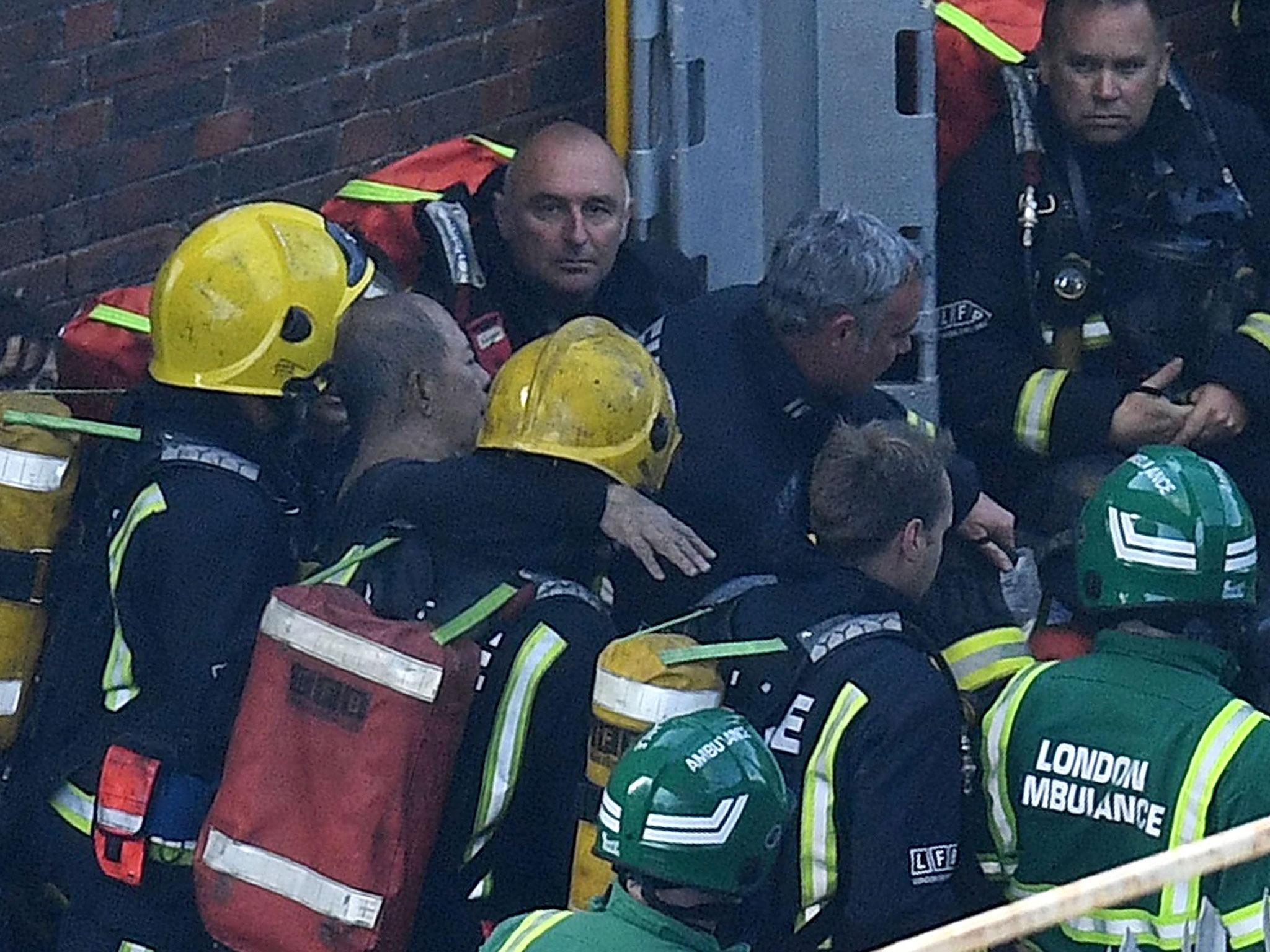Firefighters rescue a man from the huge fire that engulfed Grenfell Tower