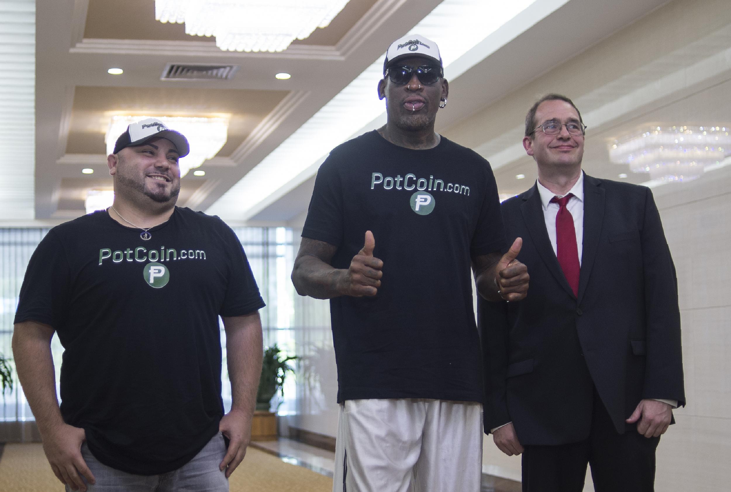 Dennis Rodman (centre) with members of his party following his arrival at Pyongyang International Airport on Tuesday