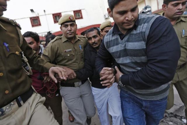 Policemen escort driver Shiv Kumar Yadav (3rd right in black jacket) who is accused of a rape outside a court in New Delhi December 8, 2014