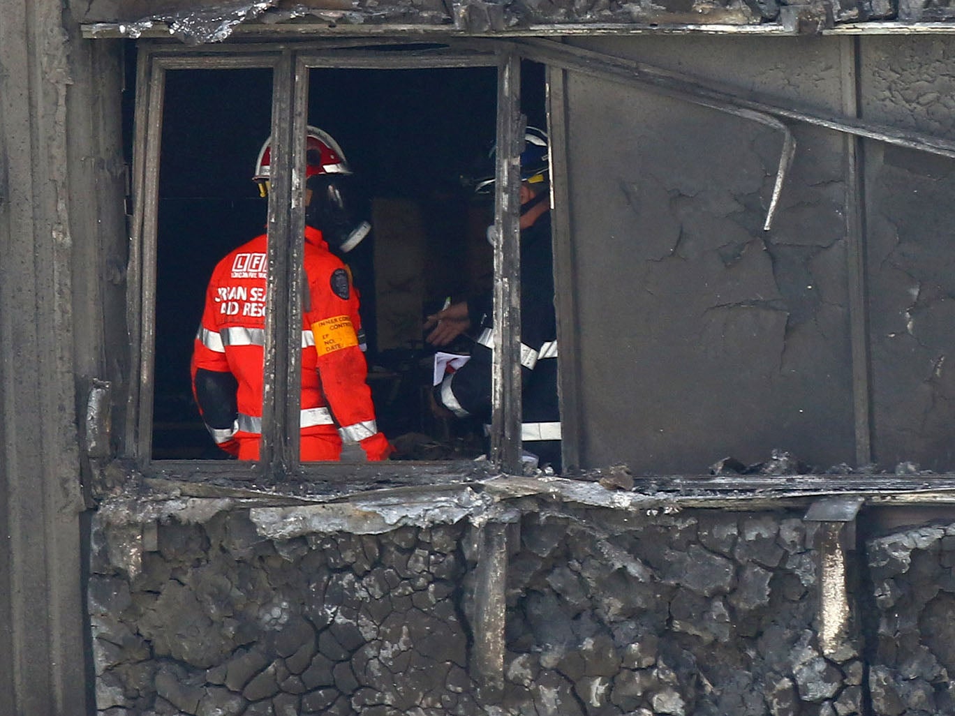 Fire service personnel survey the damage inside Grenfell Tower in west London