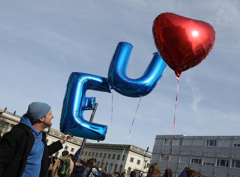 A man releases balloons at the celebration of the 60th anniversary of the Treaty of Rome
