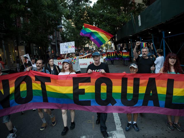 Participants march during a Flag Day 'Raise the Rainbow' rally, 14 June 2017 in New York City. The event honored LGBT rainbow flag creator Gilbert Baker, who died in March 2017. 