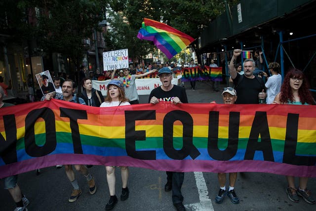 Participants march during a Flag Day 'Raise the Rainbow' rally, 14 June 2017 in New York City. The event honored LGBT rainbow flag creator Gilbert Baker, who died in March 2017. 