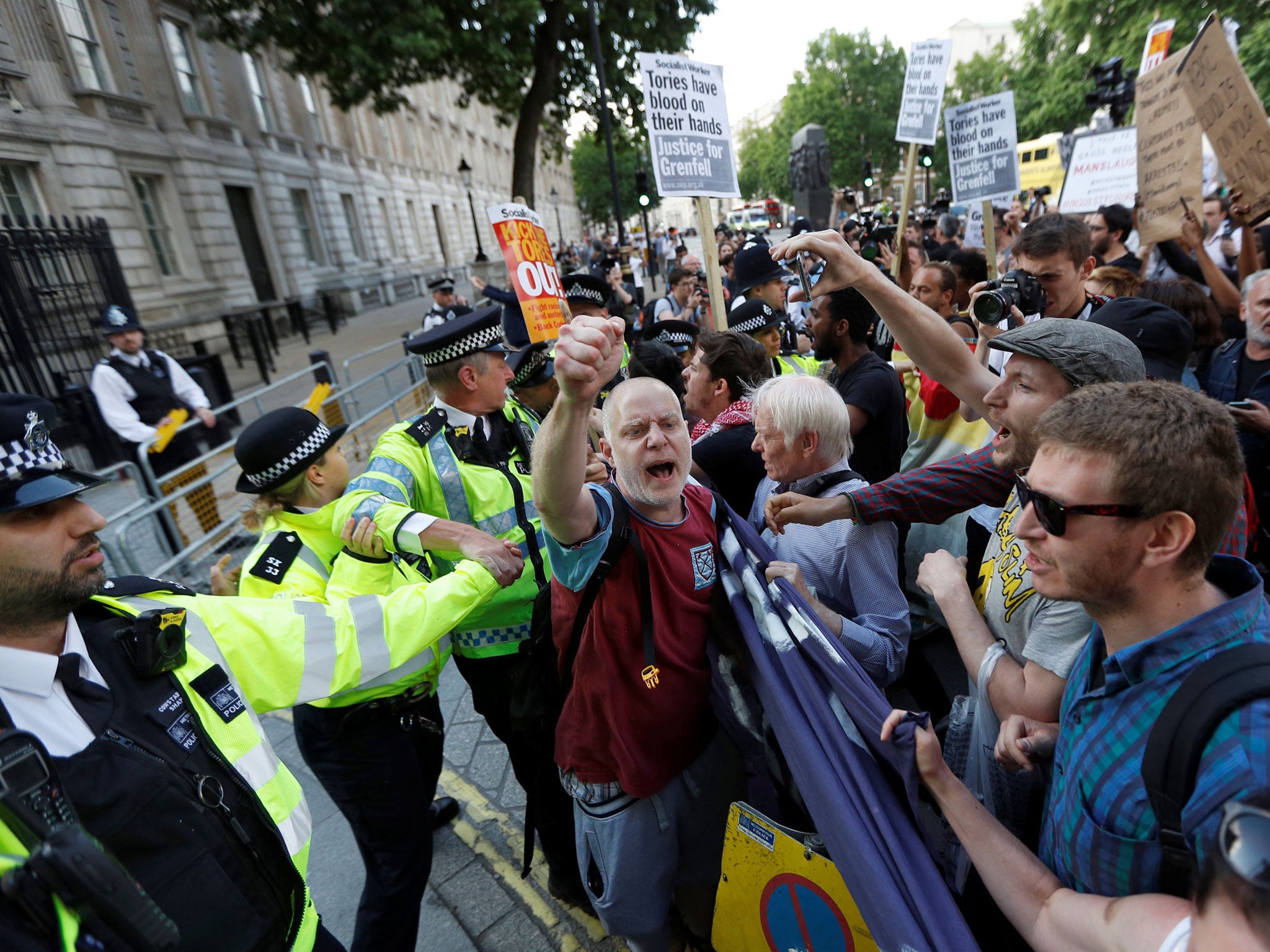 Demonstrators hold up banners during a march in Westminster following the fire that destroyed the Grenfell Tower block