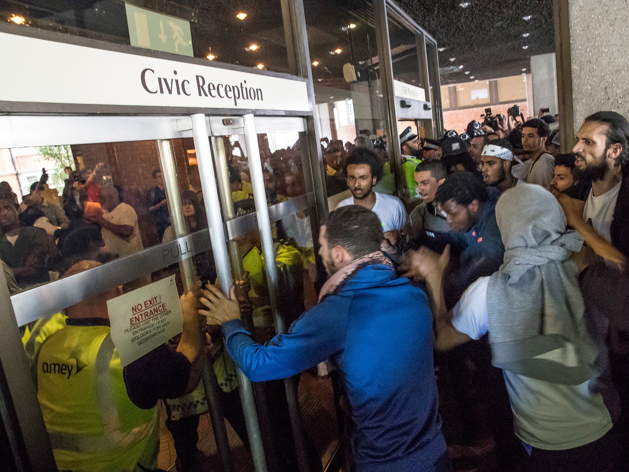 Protesters at Kensington Town Hall yesterday try to force their way into the building