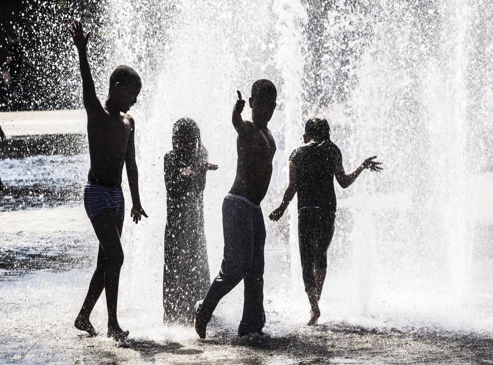 Children play in a water fountain in Bradford as Britain basks in its hottest day of the year
