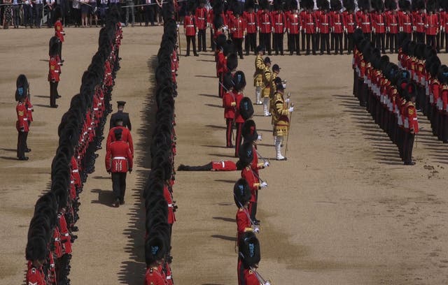 A Guardsman lies prone after fainting during the Trooping the Colour ceremony at Horse Guards Parade