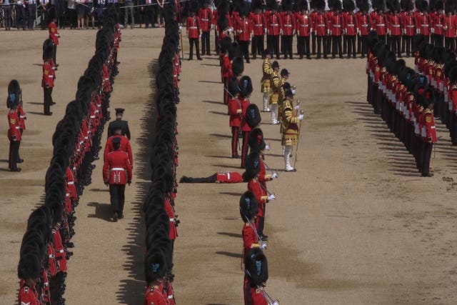 A Guardsman lies prone after fainting during the Trooping the Colour ceremony at Horse Guards Parade