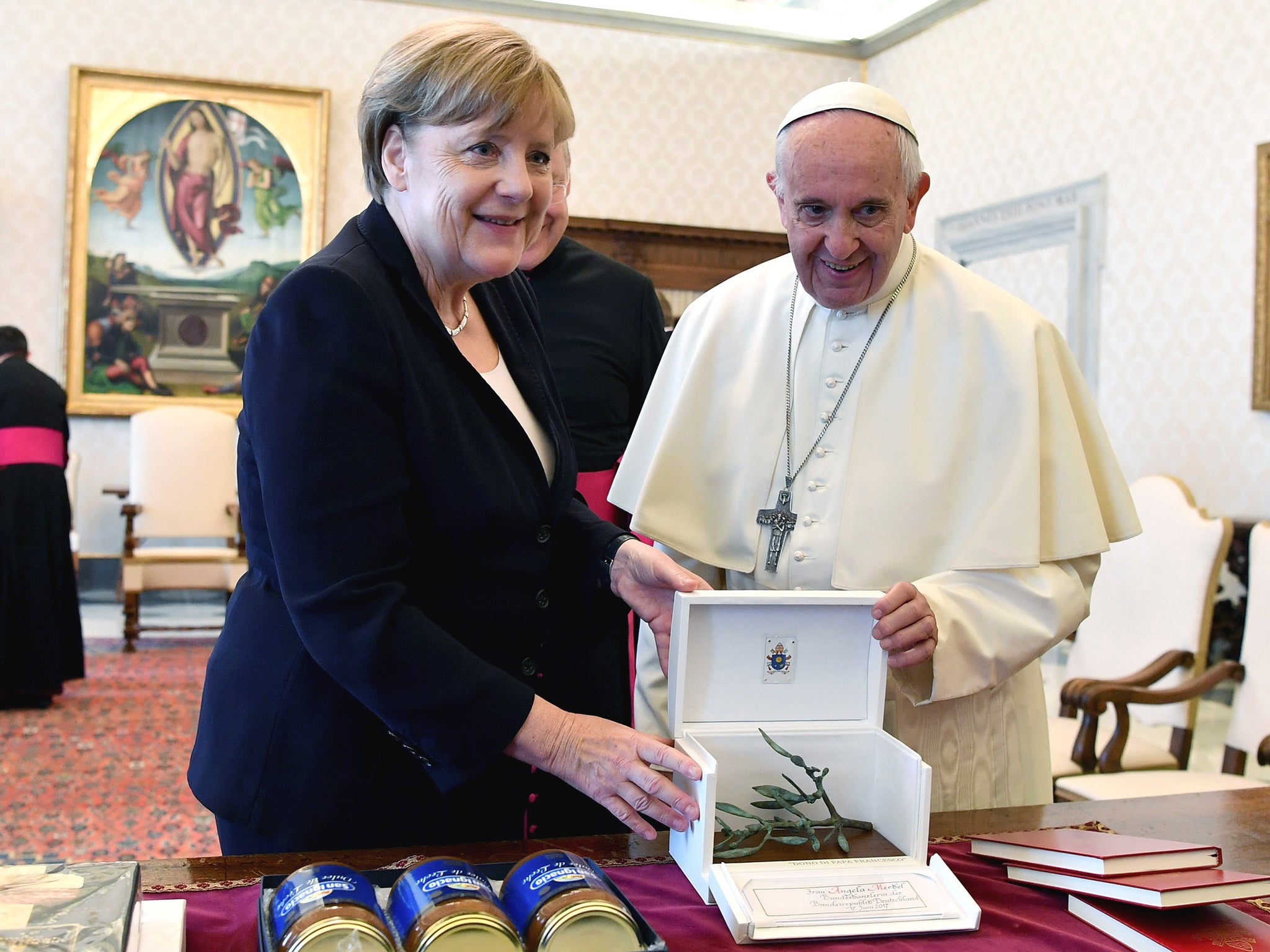 German Chancellor Angela Merkel exchanges gifts with Pope Francis during a meeting at the Vatican