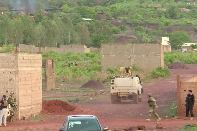 An armoured vehicle drives towards Le Campement following an attack where gunmen stormed the resort in Dougourakoro, to the east of the capital Bamako, Mali