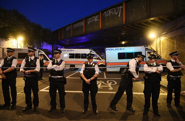 Policemen stand by a police cordon near Finsbury Park in the immediate aftermath of the attack