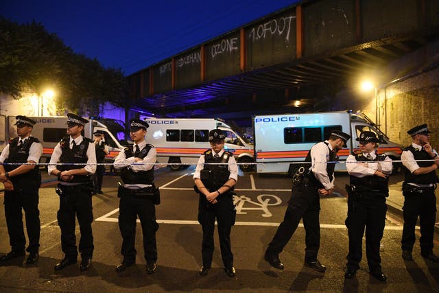 Policemen stand by a police cordon near Finsbury Park in the immediate aftermath of the attack
