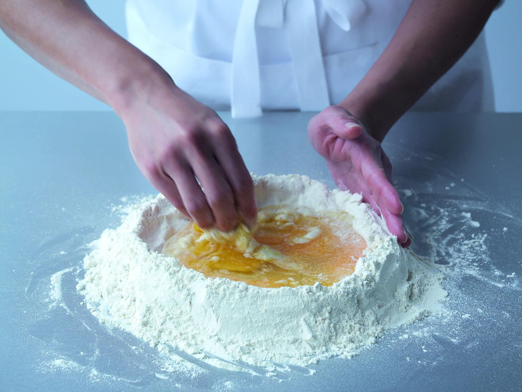 3. Using the fingers of one hand, combine the eggs and oil, gradually drawing in the flour