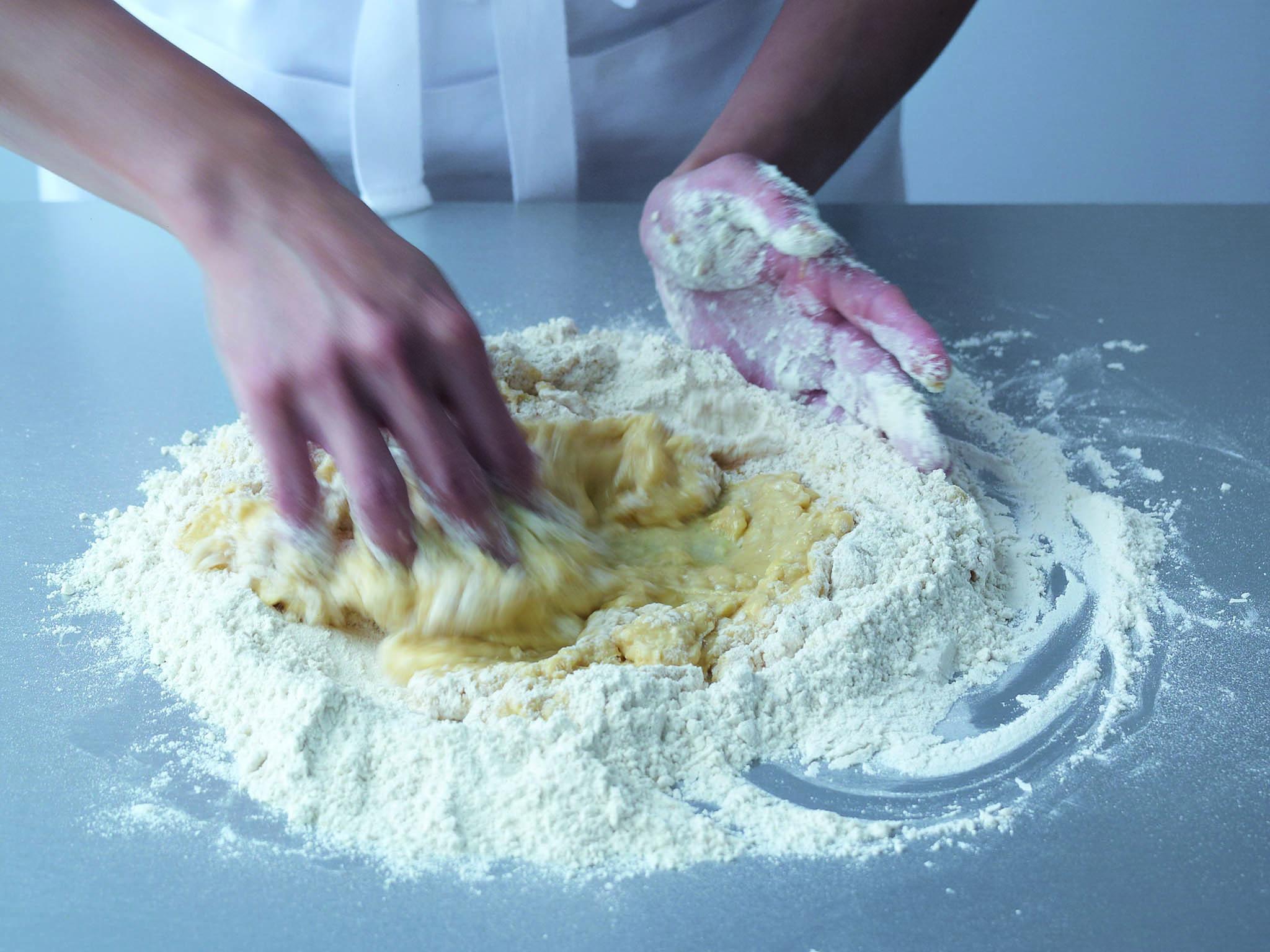 4. Continue until you have a firm, rather than wet and sticky, dough. You will not need to incorporate all the flour. Scrape aside any leftover flour to prevent it from making the dough stiffer