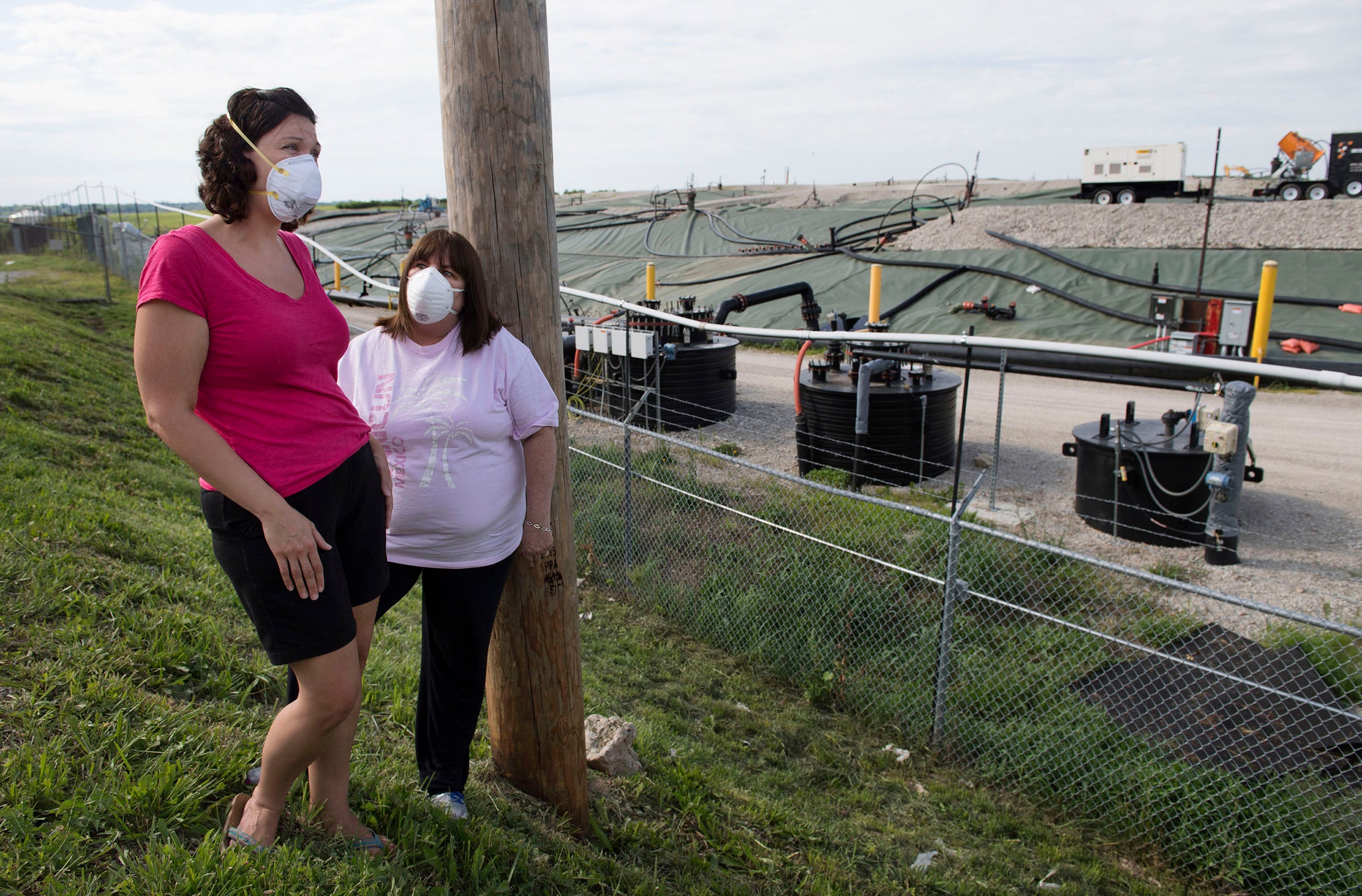Dawn Chapman, left, and Karen Nickel wear protective masks at the Superfund site near their homes in Bridgeton, Missouri