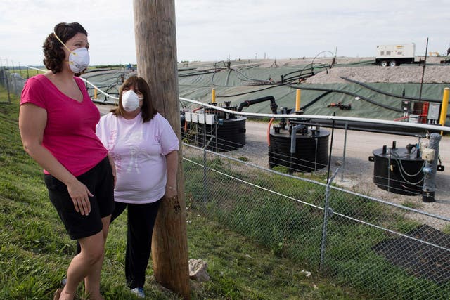 Activists Dawn Chapman, left, and Karen Nickel wear protective masks at the Superfund site near their homes in Bridgeton