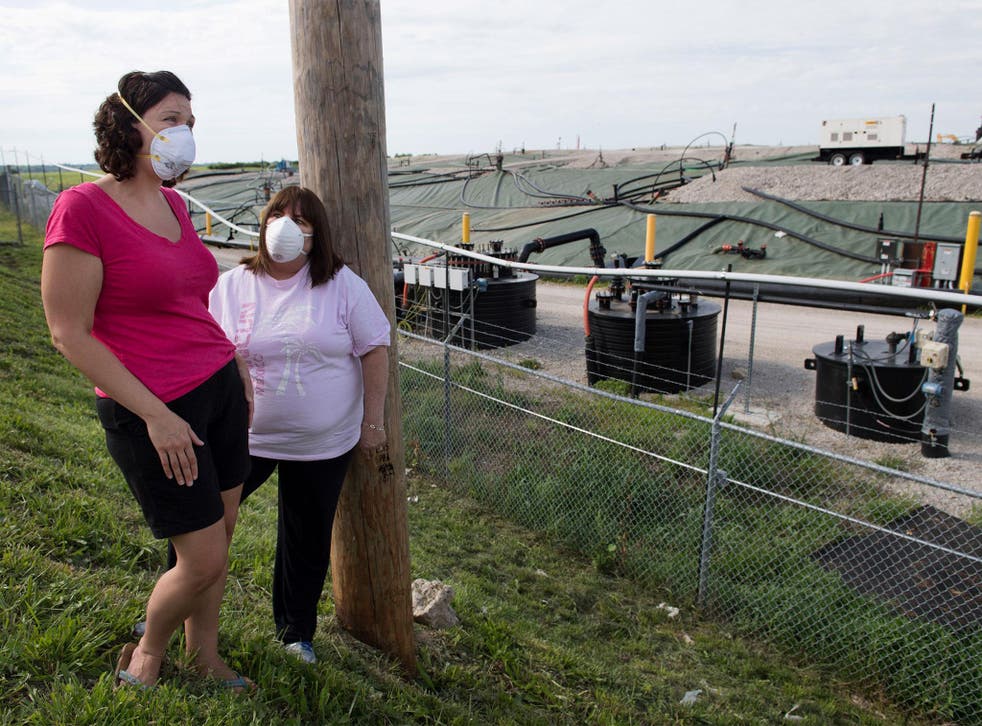 Activists Dawn Chapman, left, and Karen Nickel wear protective masks at the Superfund site near their homes in Bridgeton
