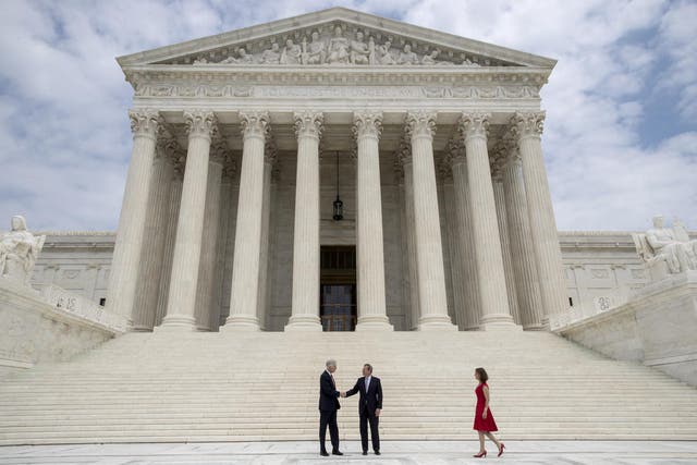 <p>Associate Supreme Court Justice Neil Gorsuch shakes hands with Chief Justice John Roberts</p>