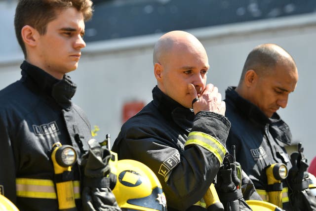 Firefighters observe a minute’s silence near the tower