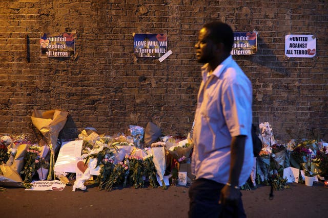 A man walks past messages and tributes left near to where a van was driven into a group of Muslim worshippers in North London