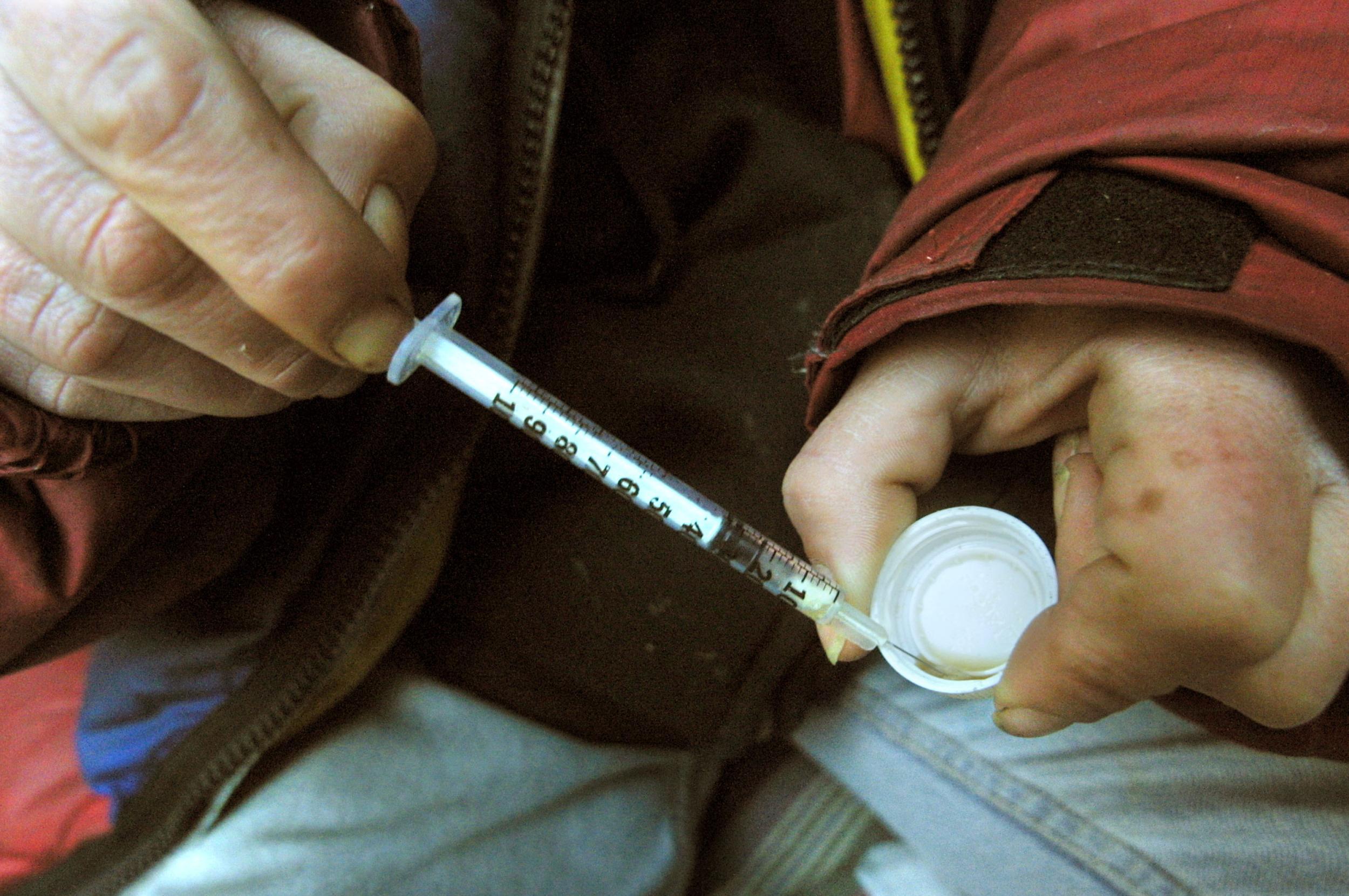 Homeless woman Joan Kimball, 37, prepares to injects herself with heroin beneath the Manhattan bridge where she lives