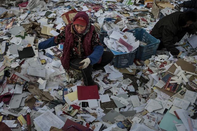 Migrant workers sorting paper in Beijing. Millions have come to the cities in search of a better life but end up living in cramped conditions with little rights