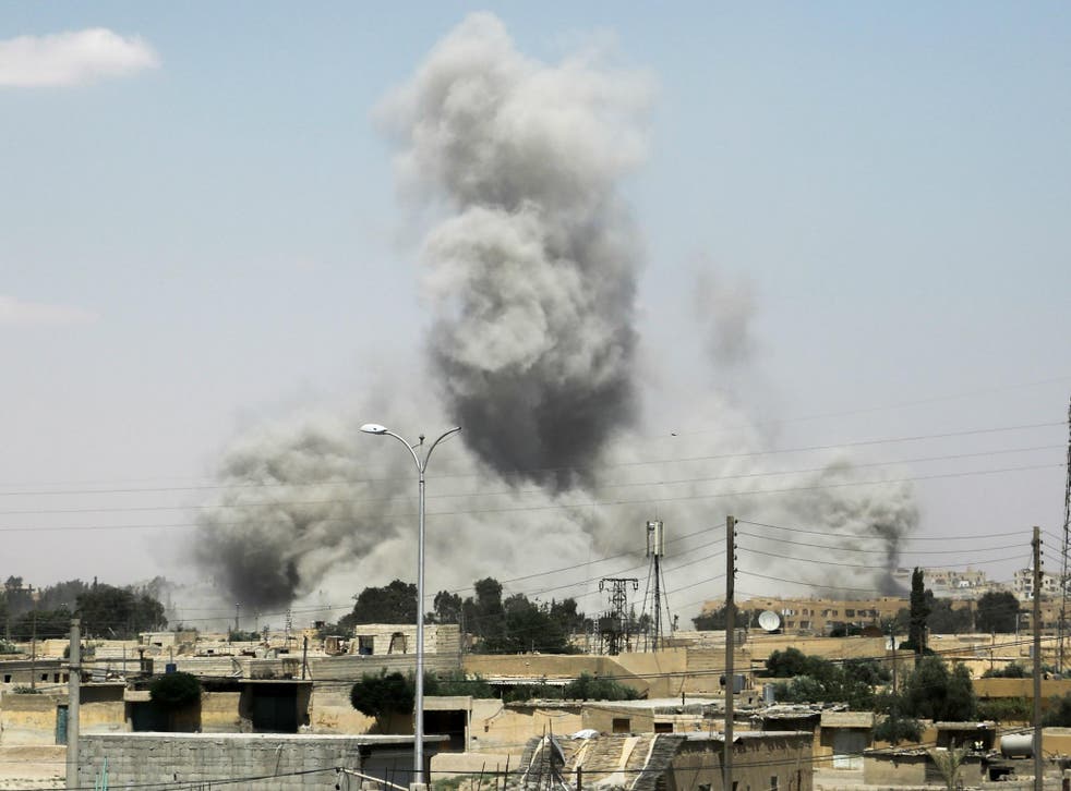 Smoke billows from buildings in the northern Syrian city of Raqqa on 18 June 2017, during an offensive by US-backed fighters to retake the Isis terror group bastion