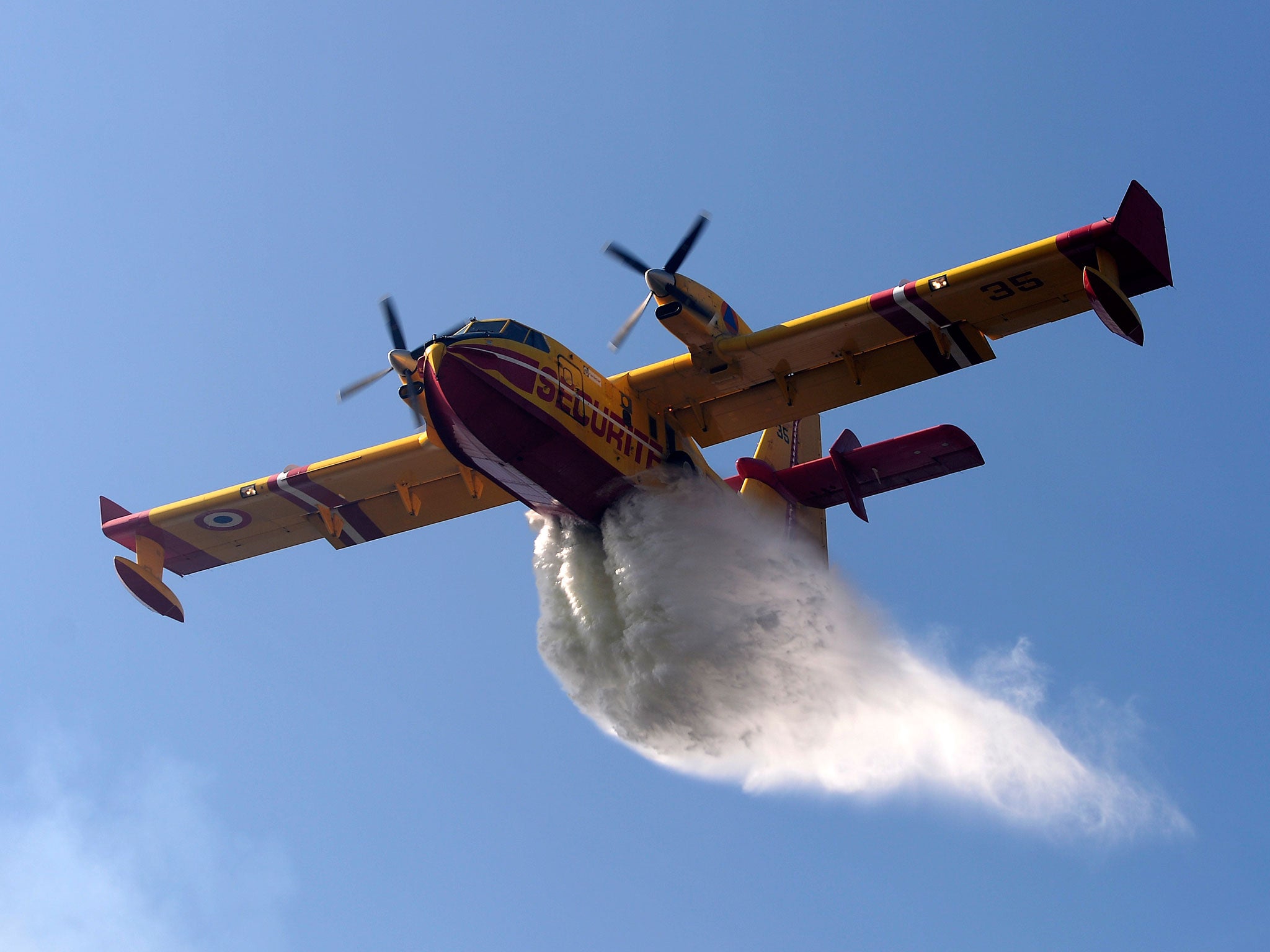 A Canadair amphibious aircraft drops its load over a wildfire in central Portugal in 2013