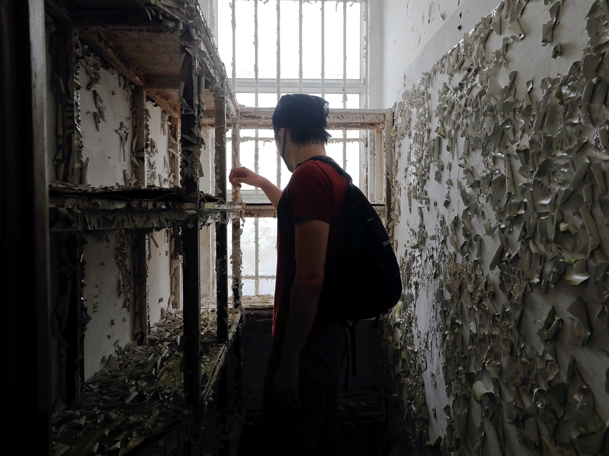 A member of HK URBEX inspects the interior of an abandoned British army barracks in Hong Kong
