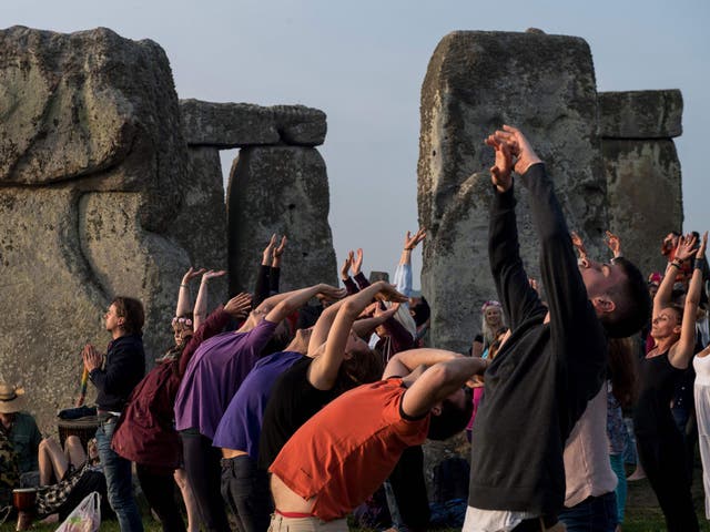Revellers practice yoga as the sun rises during the Summer Solstice at Stonehenge