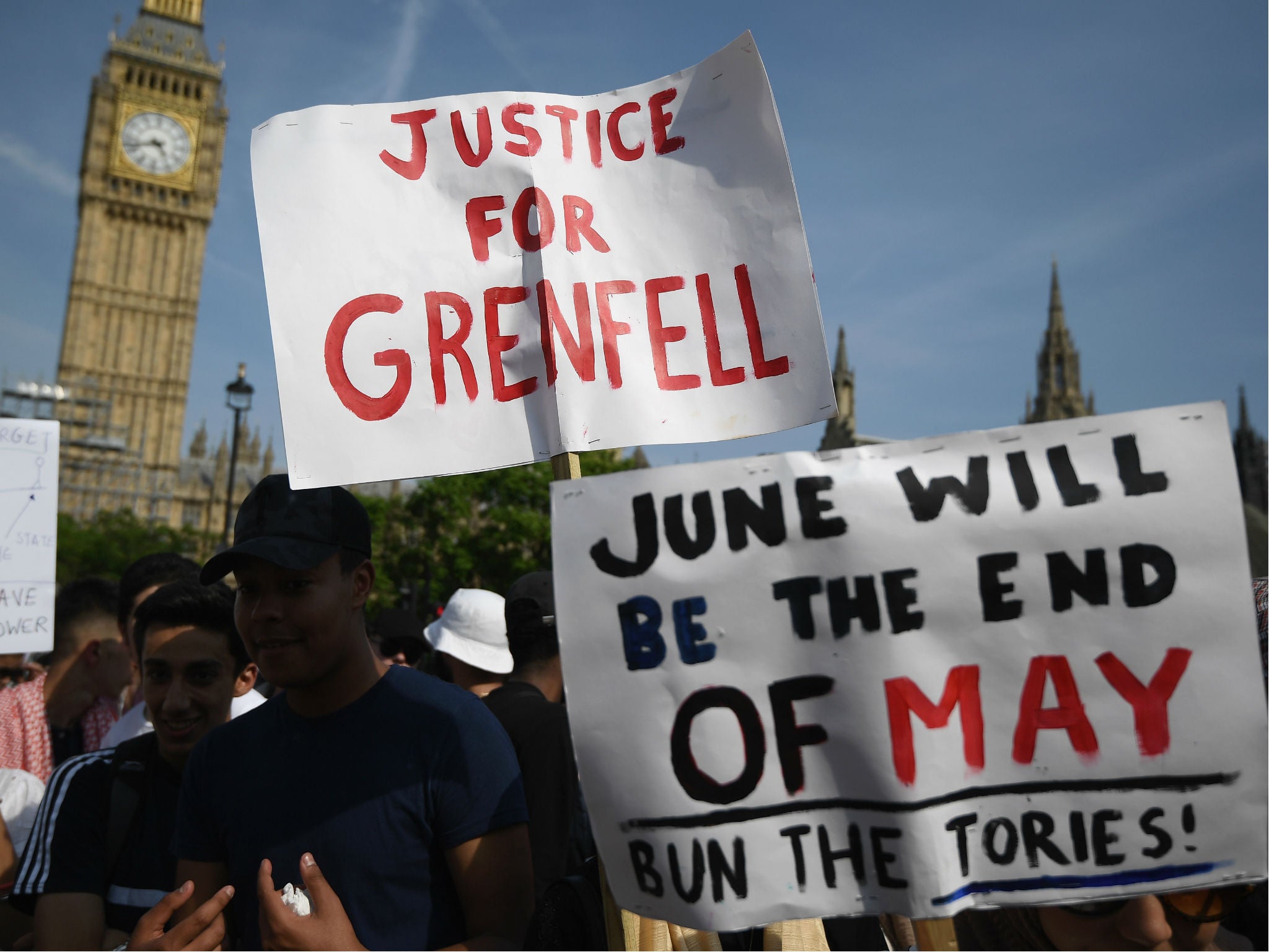 Protesters hold signs calling for a change of government and justice for the victims of the Grenfell Disaster in Parliament Square during an anti-government protest on June 21, 2017 in London, England.
