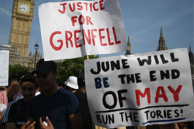 Protesters hold signs calling for a change of government and justice for the victims of the Grenfell Disaster in Parliament Square during an anti-government protest on June 21, 2017 in London, England.