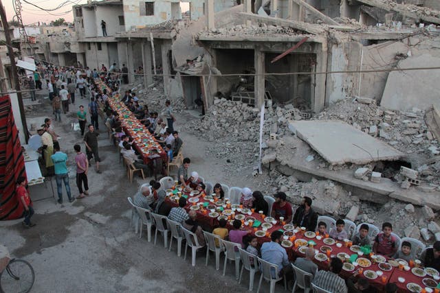 Residents of rebel-held Douma break their Ramadan fast on a damaged street on 18 June 2017