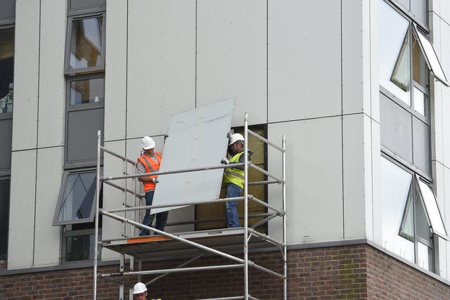 A portion of cladding being removed from a housing block in north London