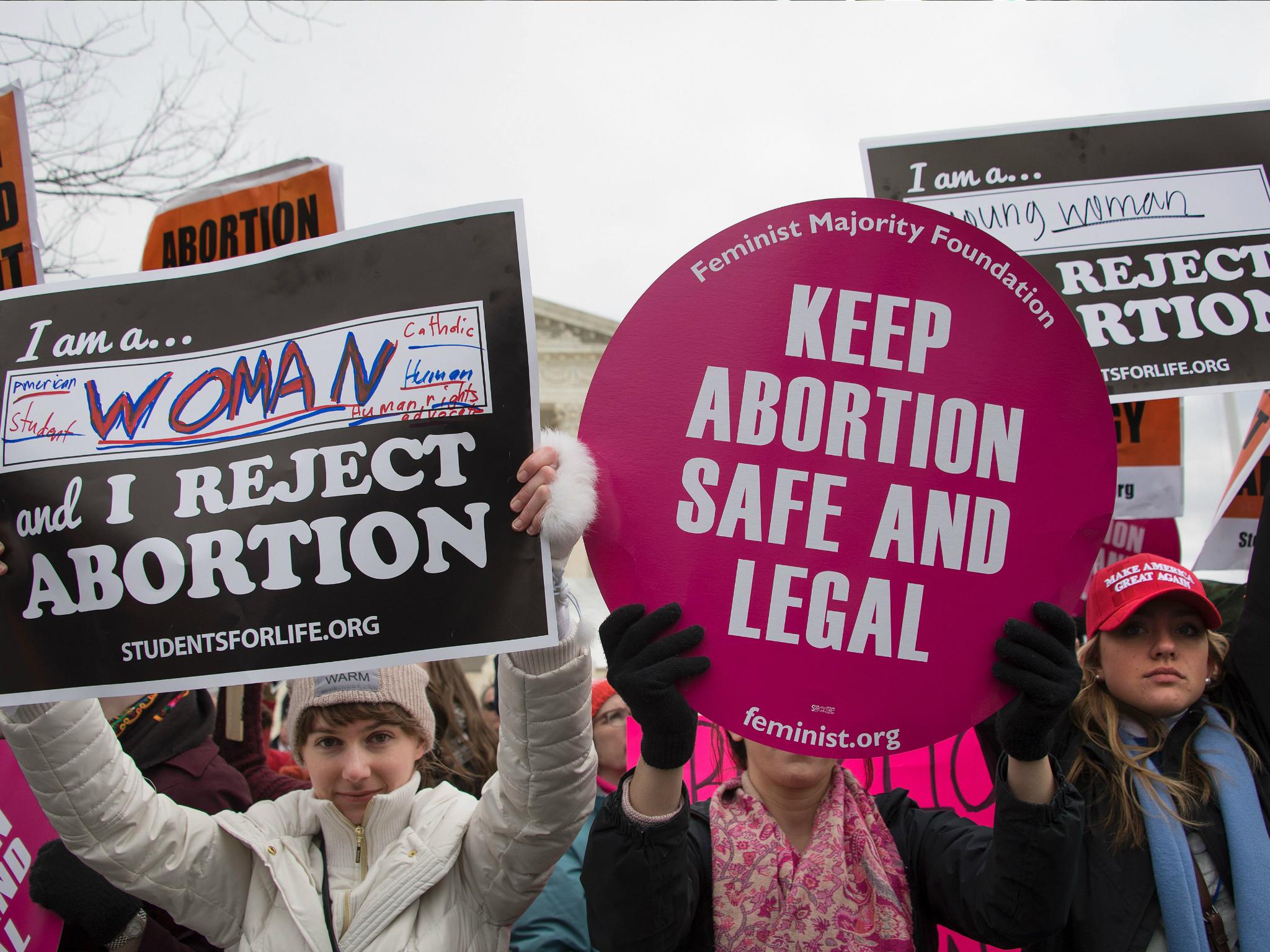 A pro-choice activist (C) demonstrates in the middle of pro-life activists as they demonstrate in front of the US Supreme Court during the March For Life in Washington DC, 27 January 2017