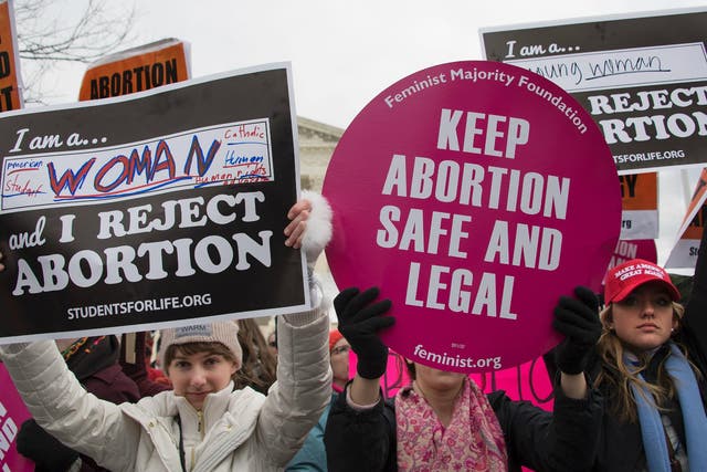 A pro-choice activist (C) demonstrates in the middle of pro-life activists as they demonstrate in front of the US Supreme Court during the March For Life in Washington DC, 27 January 2017