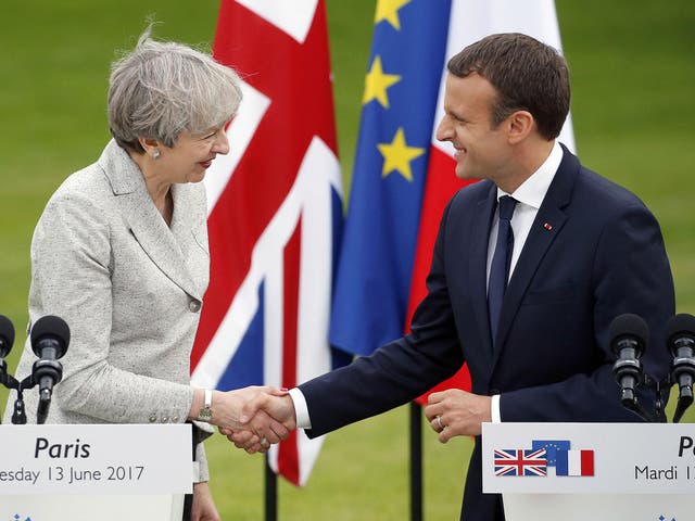 French President Emmanuel Macron shakes hands with Theresa May after a joint press conference at the Elysee Presidential Palace on 13 June