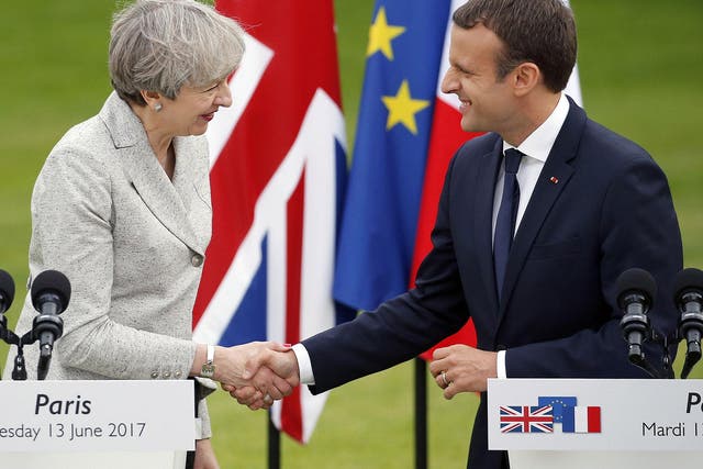 French President Emmanuel Macron shakes hands with Theresa May after a joint press conference at the Elysee Presidential Palace on 13 June