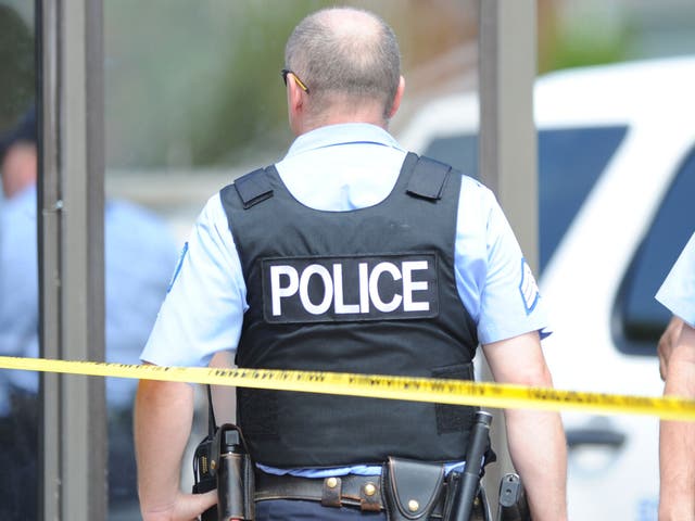 Police officers are seen at a crime scene involving a shooting of a man by St. Louis Metropolitan Police on August 19, 2014.