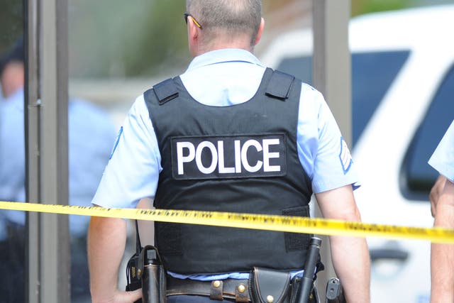 Police officers are seen at a crime scene involving a shooting of a man by St. Louis Metropolitan Police on August 19, 2014.