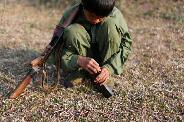 A 15-year-old rebel soldier of the Myanmar National Democratic Alliance Army inserts bullets into the clip of his rifle near a military base in Kokang region. Pictured 2015.
